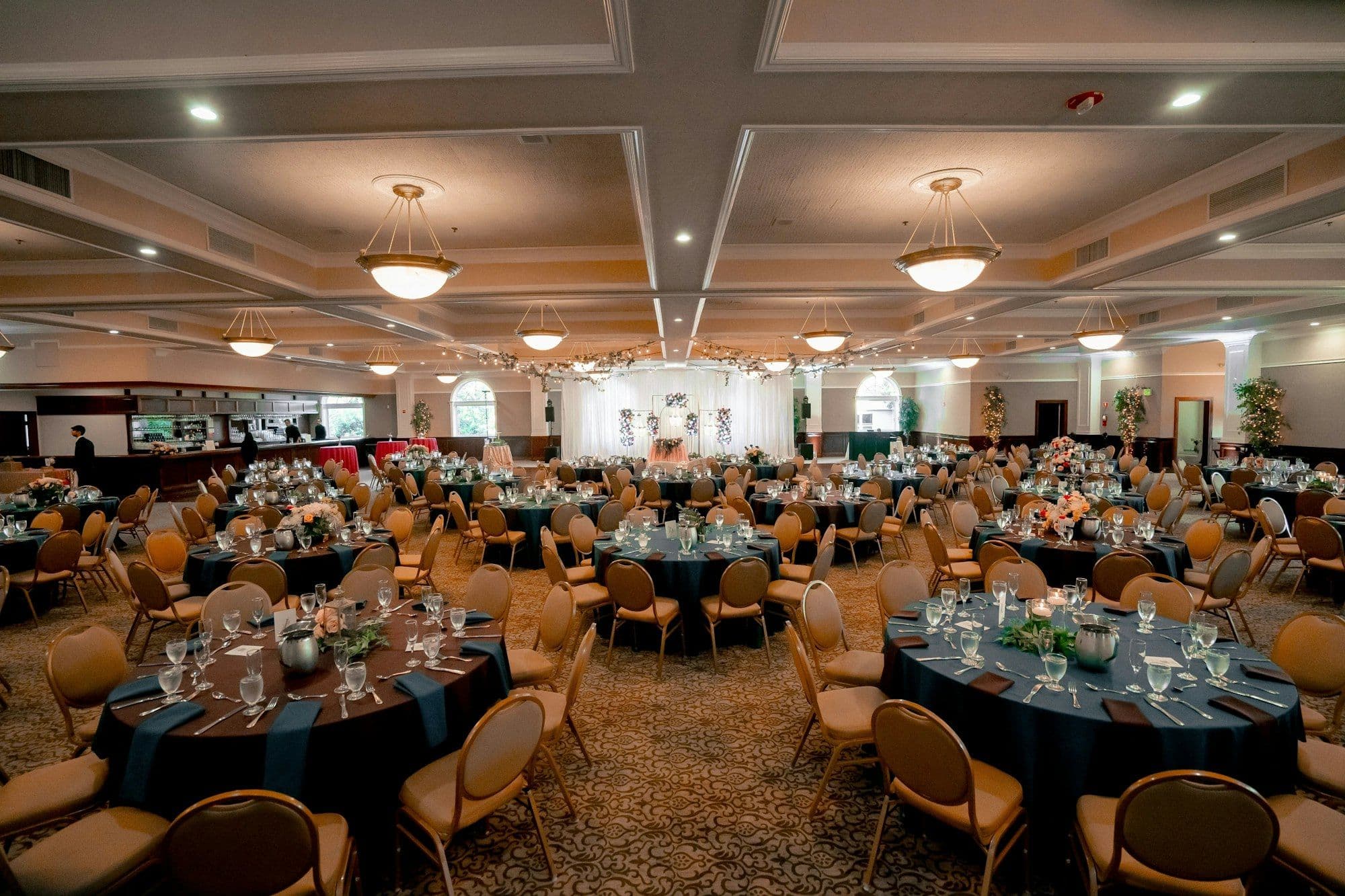 A banquet hall laid with set tables before guests arrive