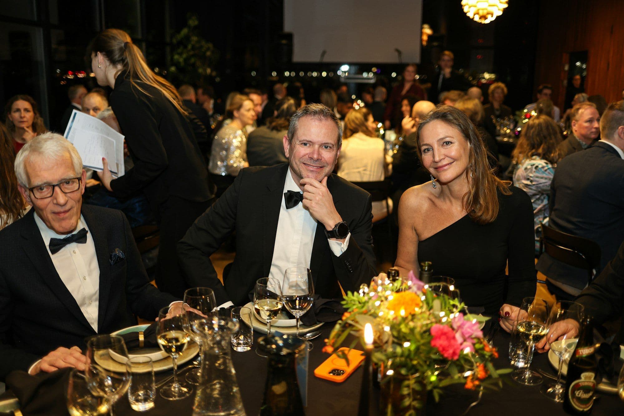 Guests seated at round tables during a charity fundraising dinner